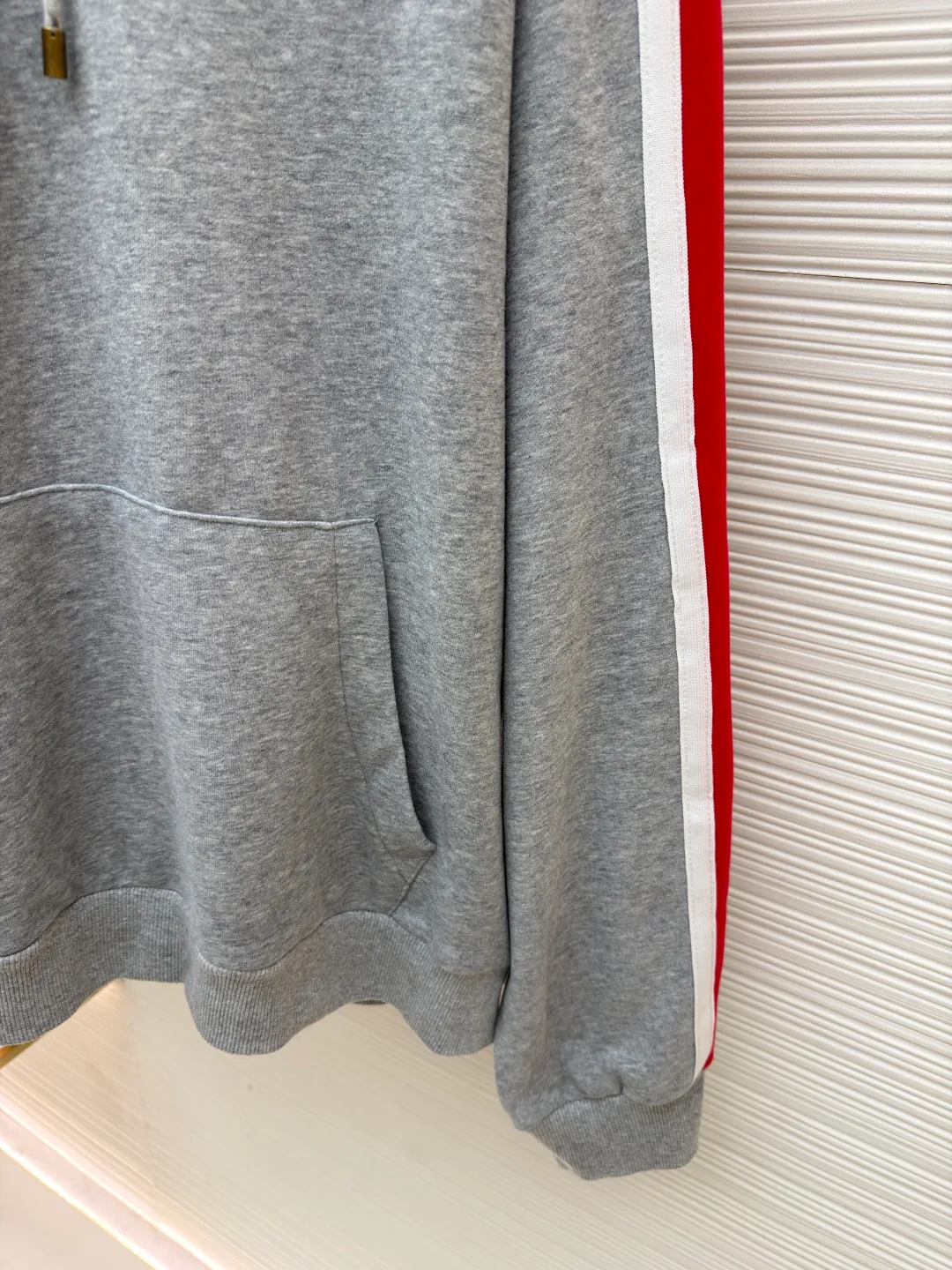 LOUIS VUITTON SKI ski series color-blocked hooded sweatshirt ●Original version: purchased and developed by 14180 ●Item number: 1681688-A95 ●Fabric: cotton fabric ●Technology: embroidery production ●Color: red, white and gray ●Version: fitted version ●Weight: about 725 grams ●Size: S-M-L-XL ●Description: This hooded sweatshirt is made of high-density cotton blend fabric and has been pre-shrunk to ensure it is not easily deformed after wearing. The main body of the shirt is gray, and the sleeves are spliced ​​with red and white webbing to create a sharp contrast. The LV logo on the chest adopts three-dimensional embroidery technology, with fine stitching and strong three-dimensional effect. The letter patterns on the sleeves also use embroidery technology, with smooth lines and rich layering. The hooded design is equipped with a drawstring with metal decoration at the end, which is both beautiful and practical. There are kangaroo pockets on both sides of the body for easy placement of small items. The cuffs and hem are ribbed to increase wearing comfort while effectively preventing wind. The overall cut is loose and suitable for a variety of body types. All sutures are made of high-strength polyester threads, which have been tested many times to ensure that they will not open during long-term wear. The overall wiring is straight and delicate, the fabric is comfortable and soft, and the color is consistent without color difference. It can be matched with the same style to create a fashionable look and control various occasions. Customized accessories, complete with three standards, same style for men and women!
